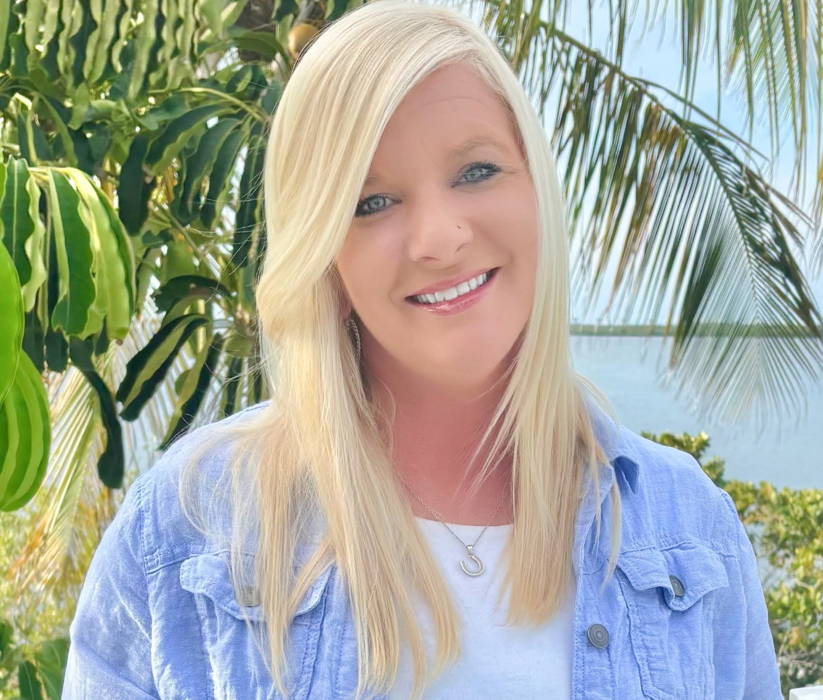 a woman standing in front of a palm tree