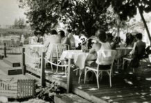 a group of people sitting at a table on a pier