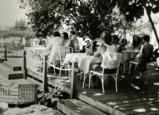 a group of people sitting at a table on a pier