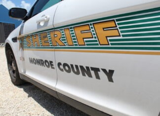 a sheriff car parked in a gravel lot
