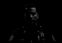 a black and white photo of a man in a police uniform