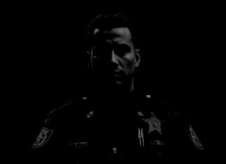 a black and white photo of a man in a police uniform