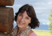a woman standing next to a wooden structure
