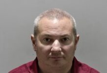 a man in a red shirt is looking at the camera