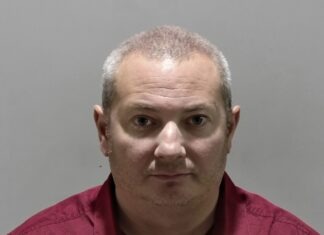 a man in a red shirt is looking at the camera