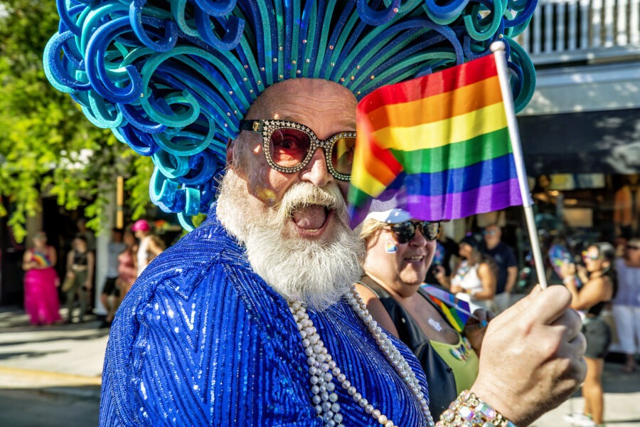 a man in a blue outfit holding a rainbow flag