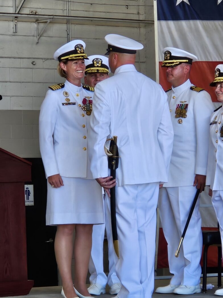 a group of people in uniform standing in front of a flag