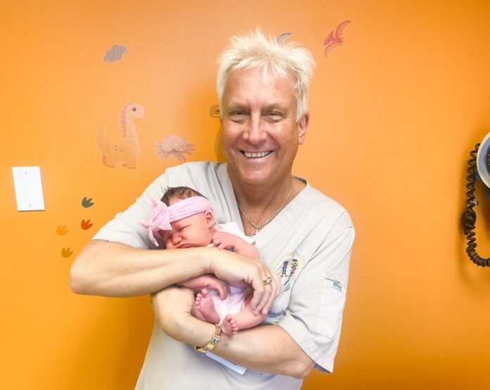 Stan Zuba a man holding a baby in his arms