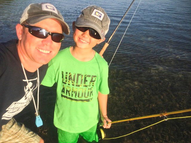 a man and a young boy fishing on a lake