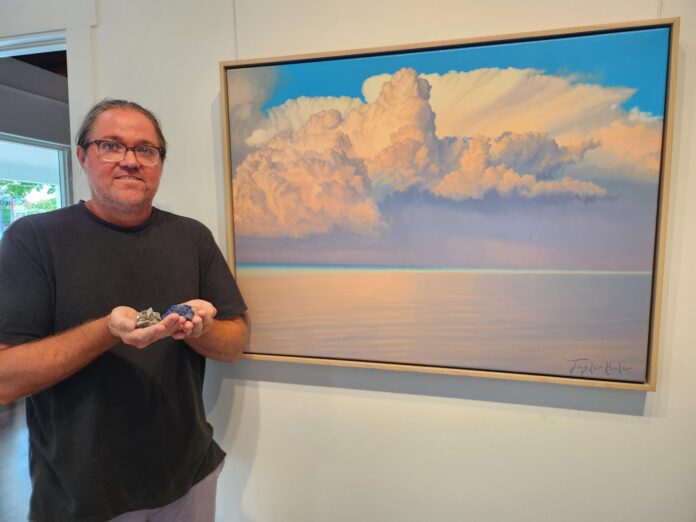 Taylor Hale Serenity Crystals Hor a man standing in front of a painting holding a controller