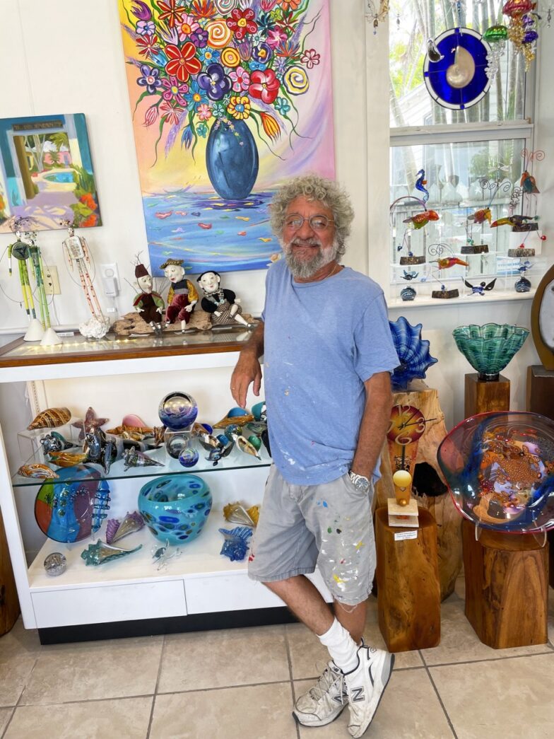 a man standing in front of a display of glass vases