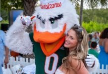 a woman standing next to a mascot at a party