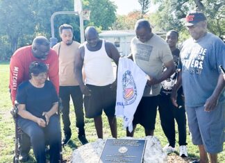 a group of people standing around a plaque