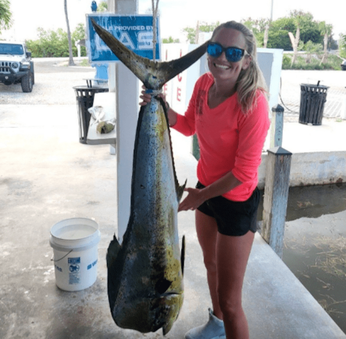 VFW tournament dolphin a woman holding a fish on a dock
