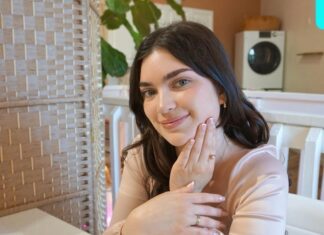 a woman sitting at a table with her hand on her face