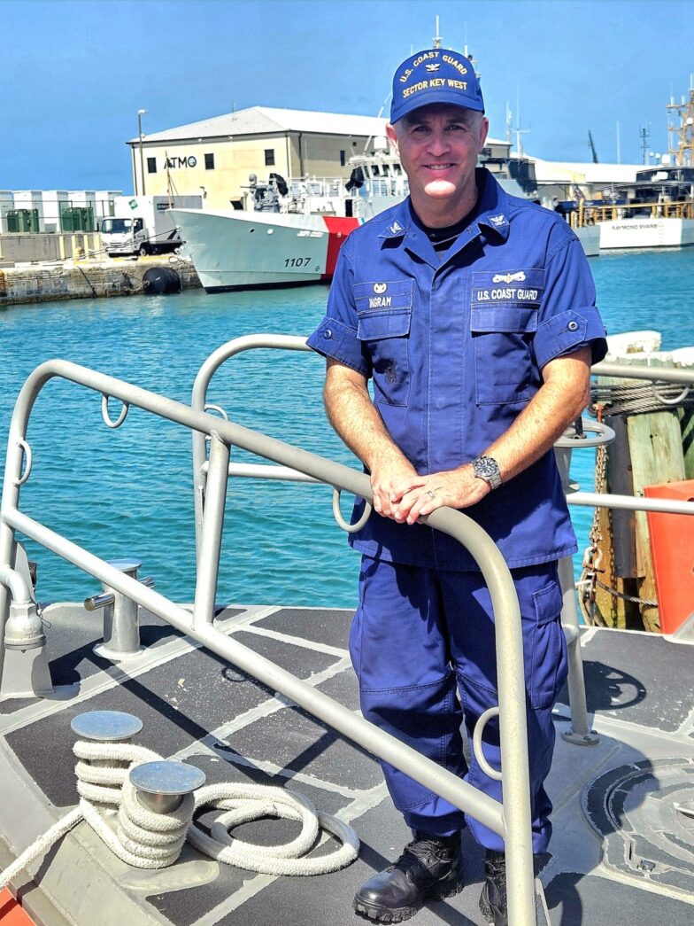 a man in a blue uniform standing on a boat