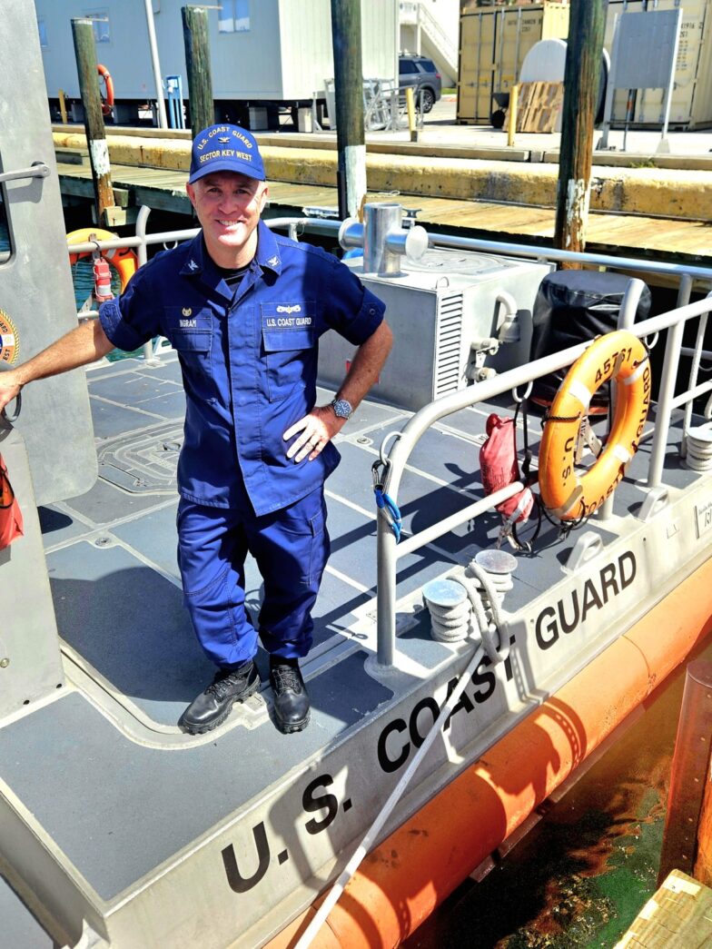a man in a blue uniform standing on a boat