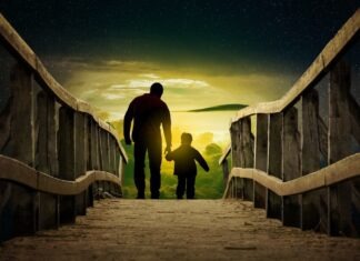 a man and a child walking across a bridge