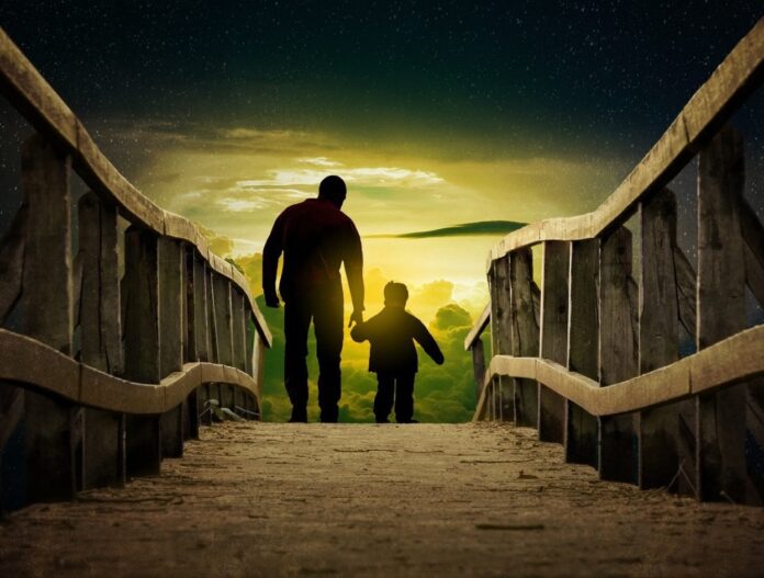 a man and a child walking across a bridge