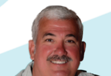 a man with a mustache is smiling for a picture