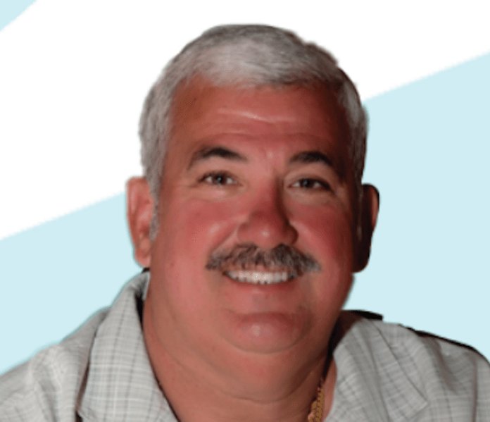 a man with a mustache is smiling for a picture