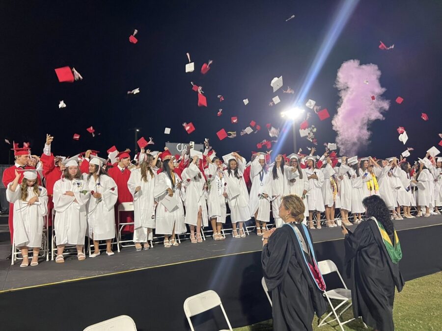 a group of graduates throwing their caps in the air