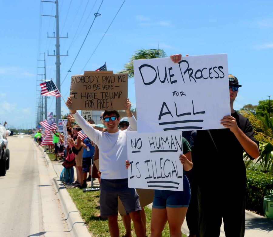 a group of people holding signs on the side of a road
