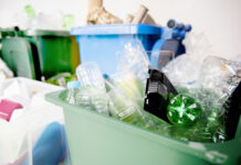 a green trash can filled with lots of garbage