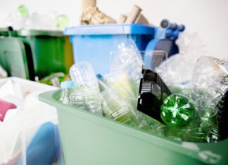 a green trash can filled with lots of garbage