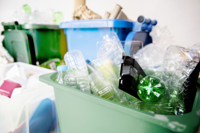 a green trash can filled with lots of garbage