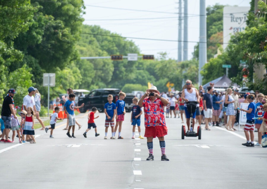a group of people standing on the side of a road
