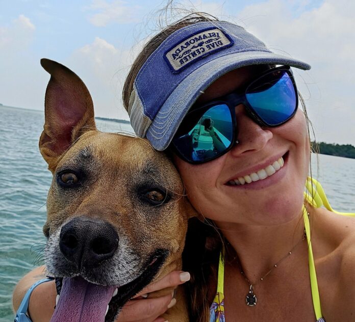 a woman and her dog are on a boat