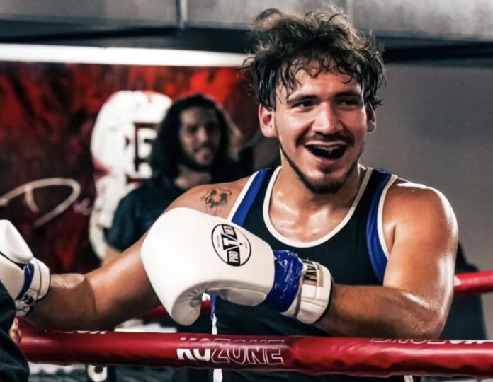 a man standing next to a red boxing ring