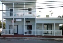 a two story white building with a white balcony