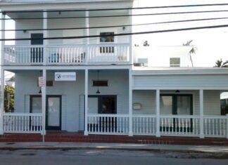 a two story white building with a white balcony