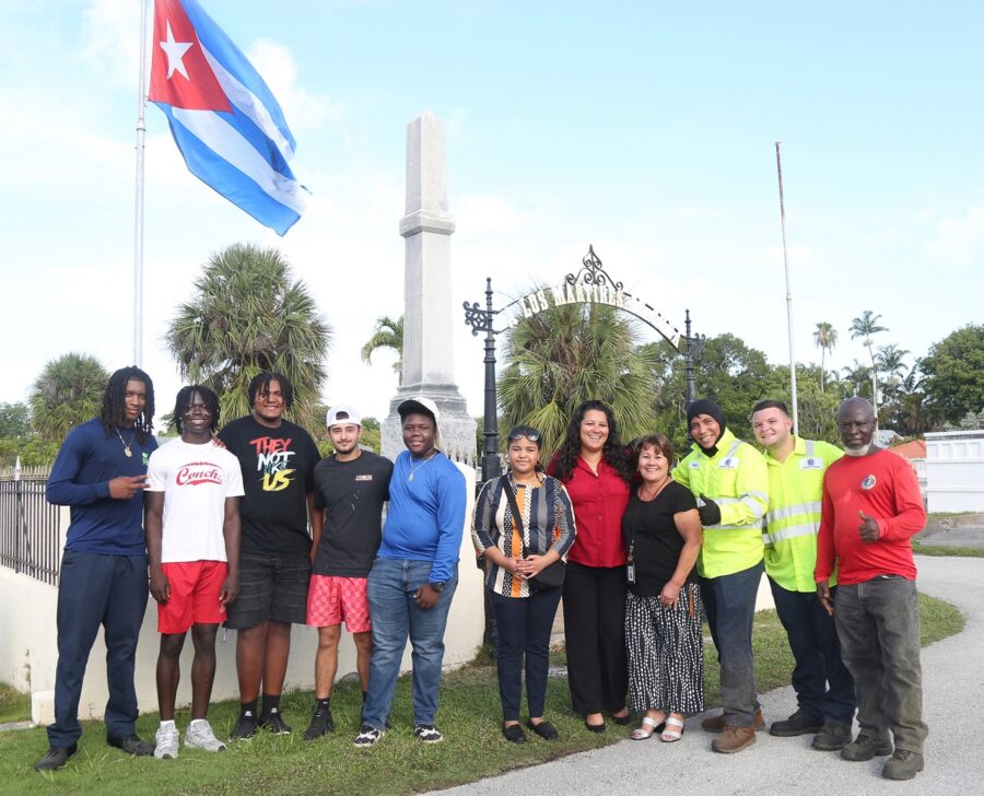 a group of people standing in front of a flag pole