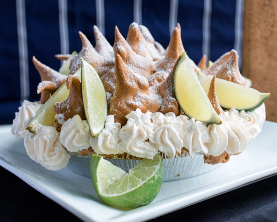 a cupcake on a plate with limes and other toppings