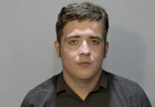 a man in a black shirt is looking at the camera