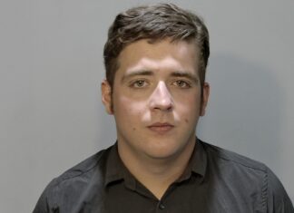 a man in a black shirt is looking at the camera