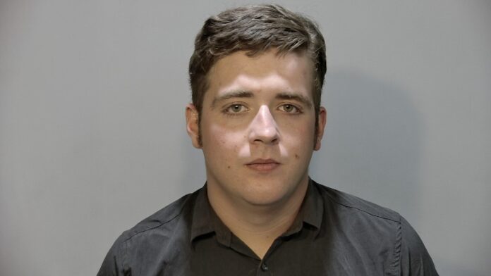 a man in a black shirt is looking at the camera