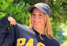 a woman holding onto a sweatshirt with the word pac on it