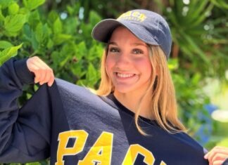 a woman holding onto a sweatshirt with the word pac on it