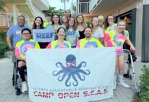 a group of people holding a sign in front of a building