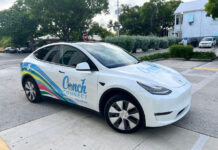 a white electric car parked in a parking lot