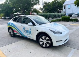 a white electric car parked in a parking lot