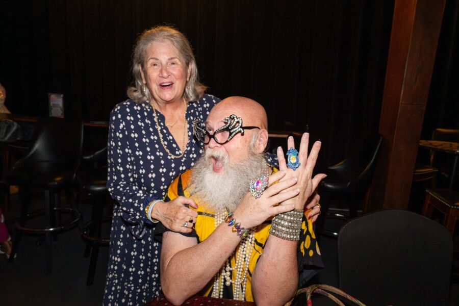 a man with a beard hugging a woman at a table