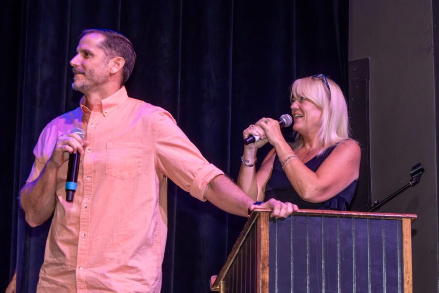 a man and a woman standing on a stage with microphones