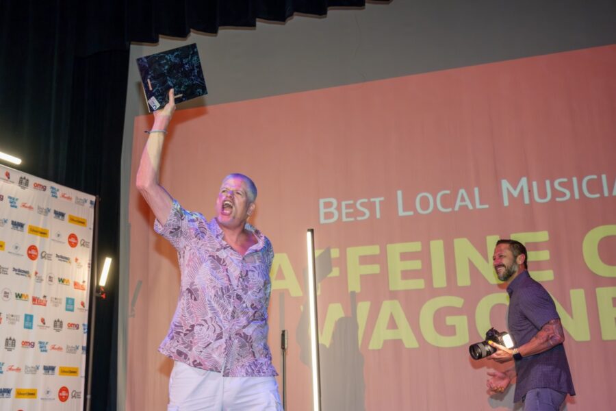 a man standing on a stage with his arms in the air