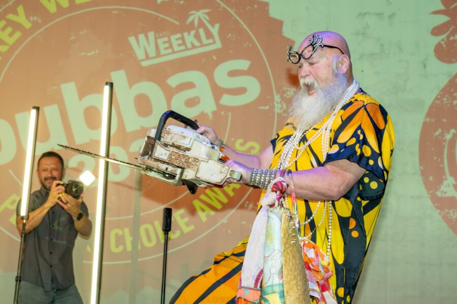 a man standing on a stage with a saw