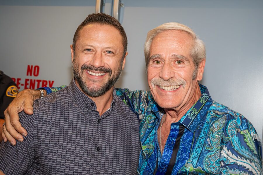 two men standing next to each other smiling